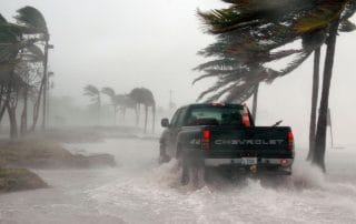 Inspection crews driving through a storm, highlighting the need for new ROV inspection technology for pre-storm checks in Florida.