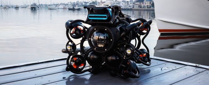 SRV-8 ROV sitting on a dock with a large boat in the water behind it
